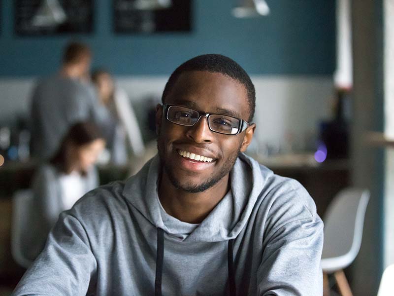 Portrait of smiling black man looking at camera in cafe